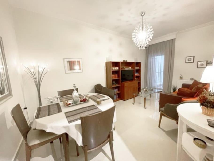 salon ze stołem i krzesłami oraz jadalnią w obiekcie Crimson Suite: 1-bedroom apartment in Thessaloniki w Salonikach