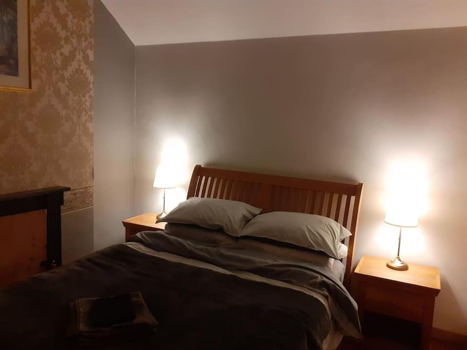Characterful Cottage near the Sea, Beach, Pier & Shops في ويستون سوبر مير: غرفة نوم مع سرير مع مصباحين على طاولتين