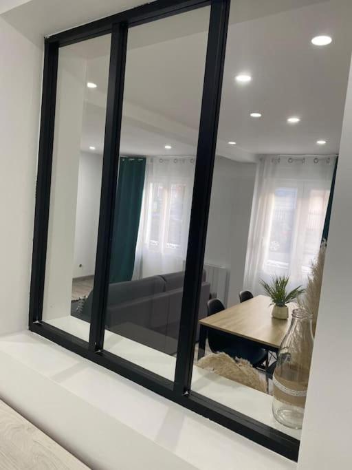 - un miroir dans le salon avec une table dans l'établissement Colmar,appart chaleureux 2 pas centre avec jardin, à Colmar