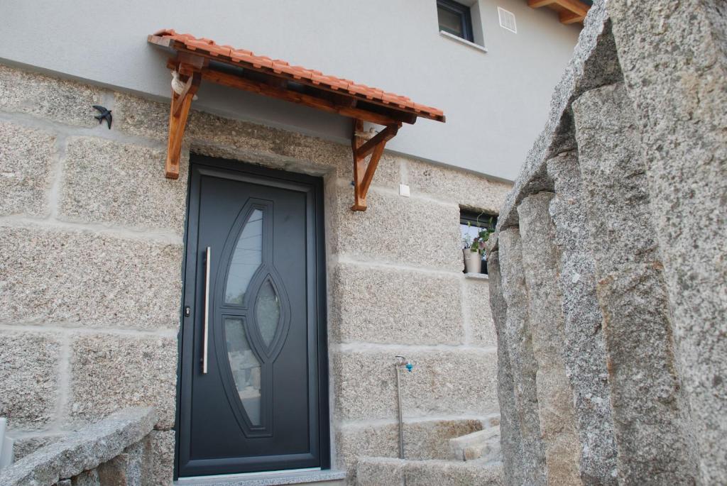 a black door on the side of a stone building at Superb Bruzende Village in Baião