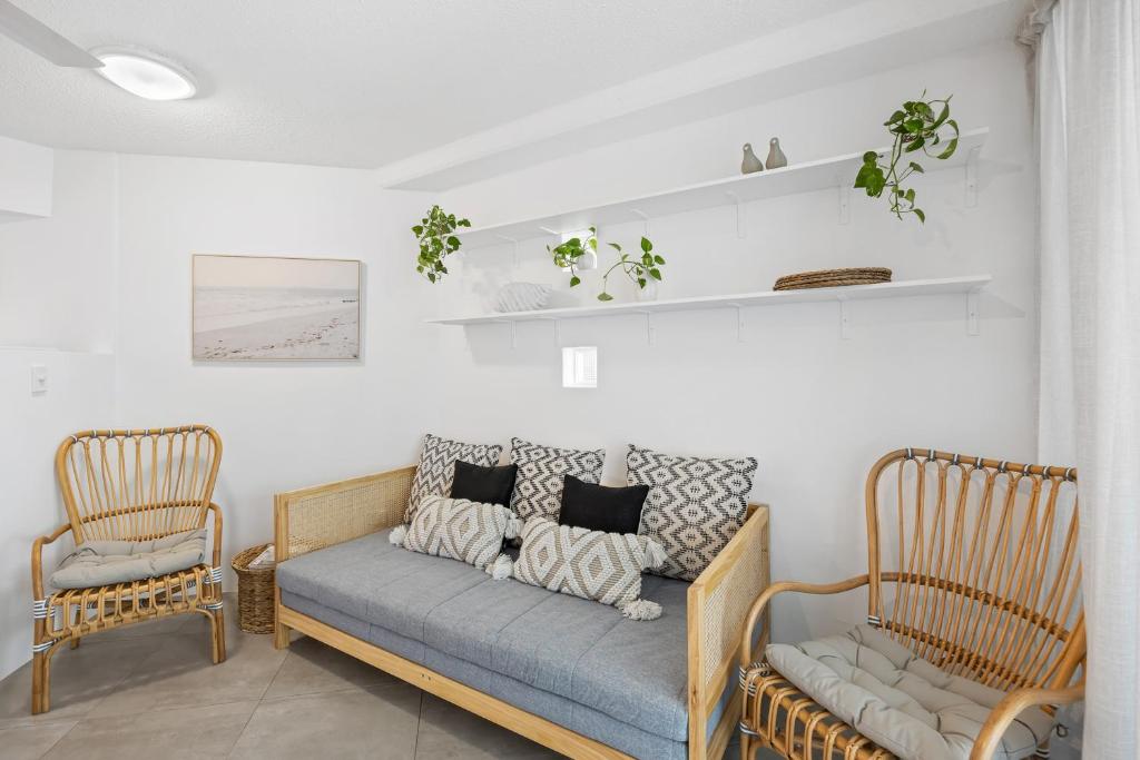 ein Wohnzimmer mit einem Sofa und 2 Stühlen in der Unterkunft Beach Club Delight in Mooloolaba