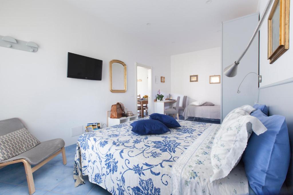 a blue and white bedroom with a bed and a chair at Cafiero Flat in Sorrento