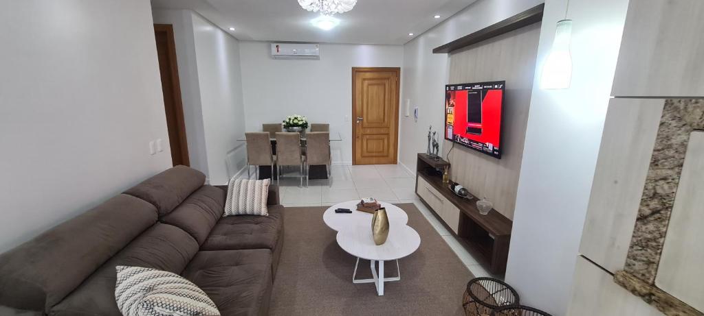 Excelente Apartamento Alto Padrão Centro Ed Dubai في كاباو دا كانوا: غرفة معيشة مع أريكة وتلفزيون