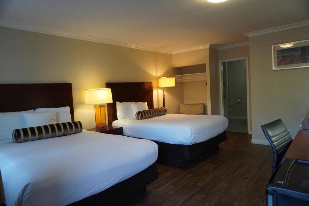 une chambre d'hôtel avec 2 lits et 2 lampes dans l'établissement Rose Garden Inn, à Santa Barbara