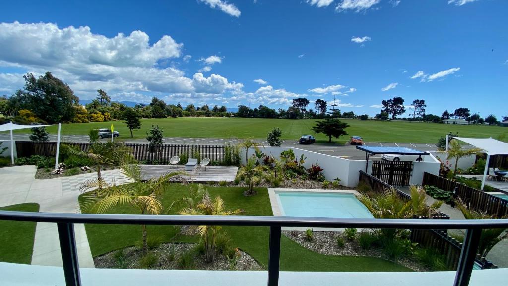 a view of a golf course from the balcony of a house at Tahuna Beach Apartment in Nelson