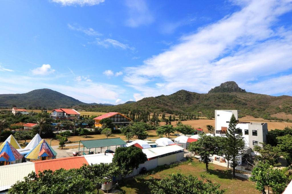 a village with tents and mountains in the background at Kenting Peninsula Inn in Kenting