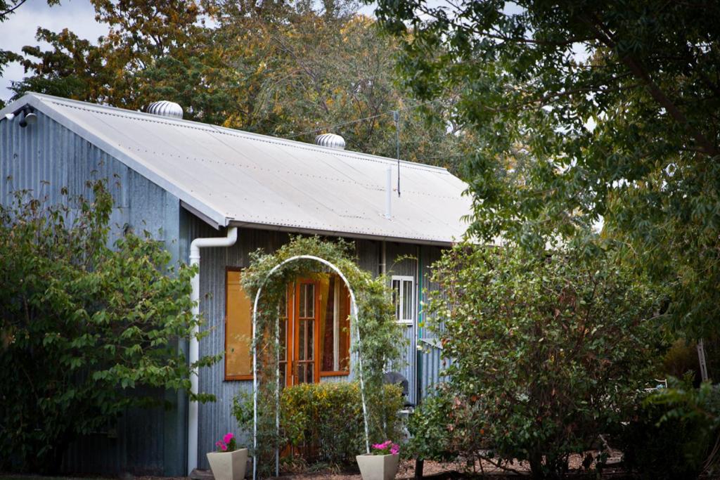 una casa azul con un arco delante de ella en Riverlea Cottage en Apple Tree Flat
