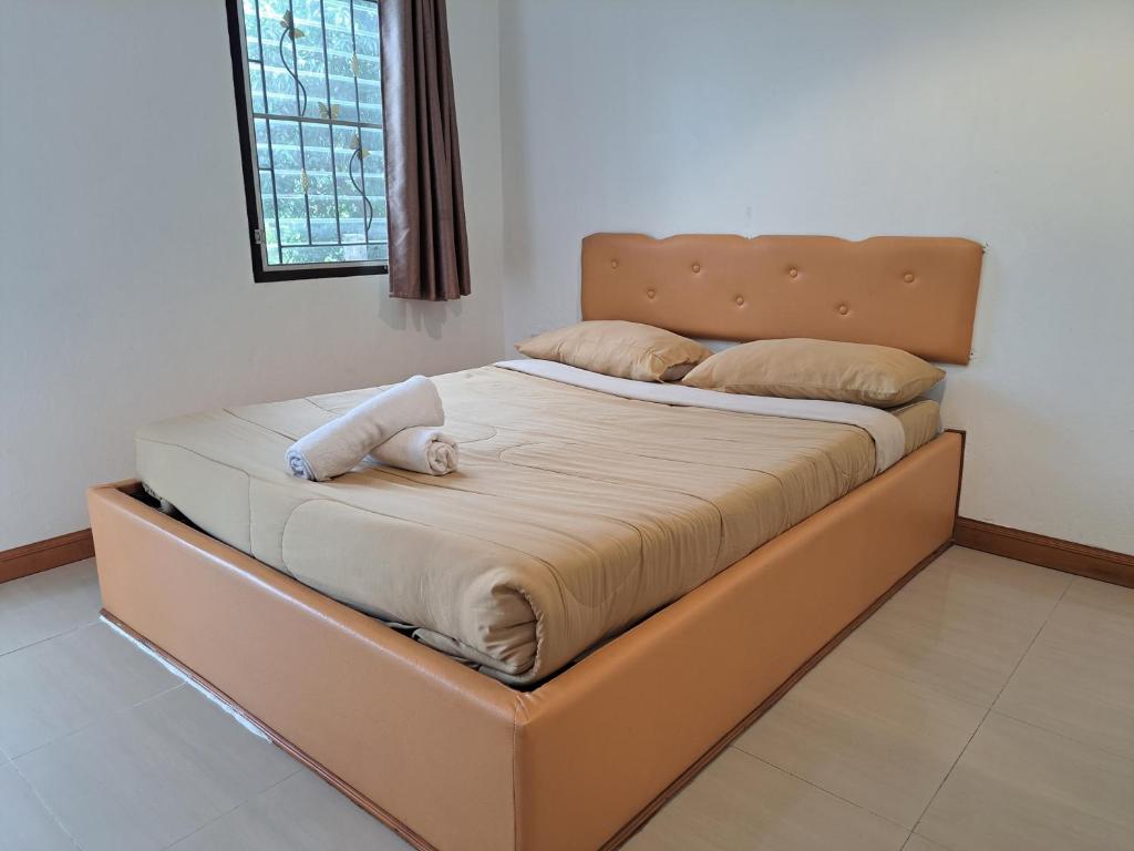 Una cama con un animal de peluche encima. en ไวท์ เอลเลแฟนต์ รีสอร์ท en Nakhon Nayok