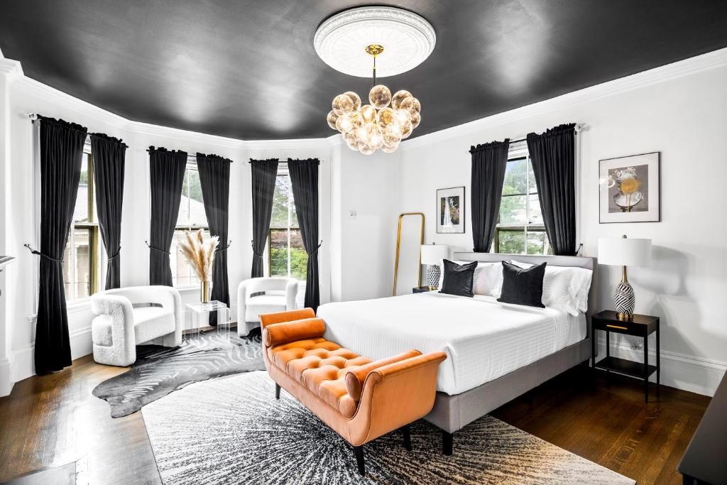 a bedroom with a bed and a chair and a chandelier at The Coach House in Salem