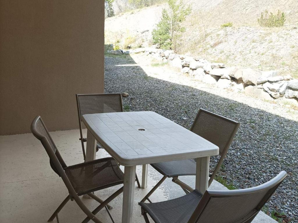una mesa con 2 sillas y una mesa y sillas blancas en Studio Jausiers, 1 pièce, 4 personnes - FR-1-165B-56 en Jausiers