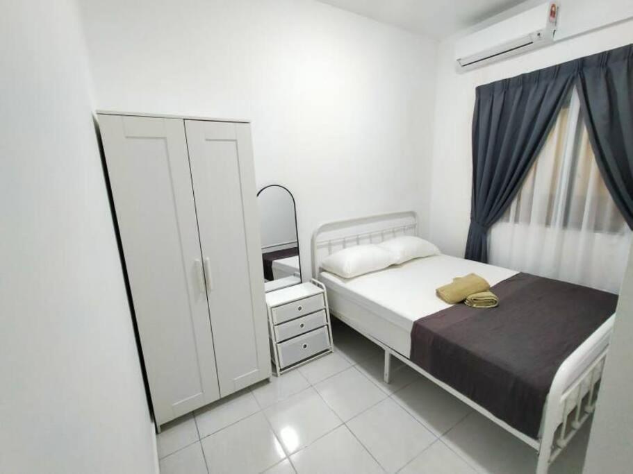 a small bedroom with a bed and a dresser at SS CondoStay Residensi Lili, Nilai nearby KLIA, USIM - infinity pool, wifi, smart tv in Nilai