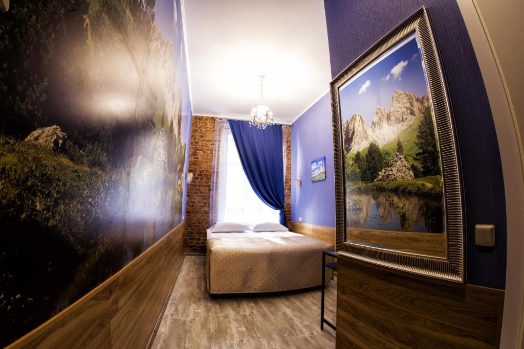 a bedroom with a bed and a painting on the wall at Bonjour Hotel in Saint Petersburg