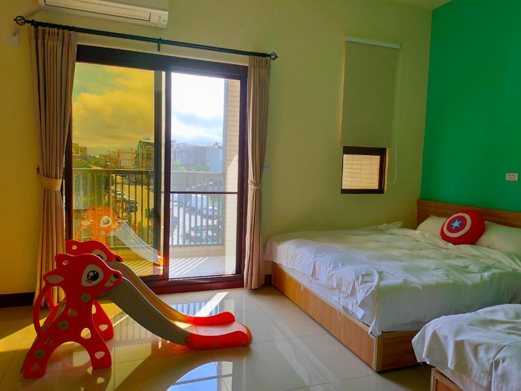Un dormitorio con 2 camas y una ventana con un tobogán. en 童趣漫旅溜滑梯民宿 可預約包棟, en Taitung