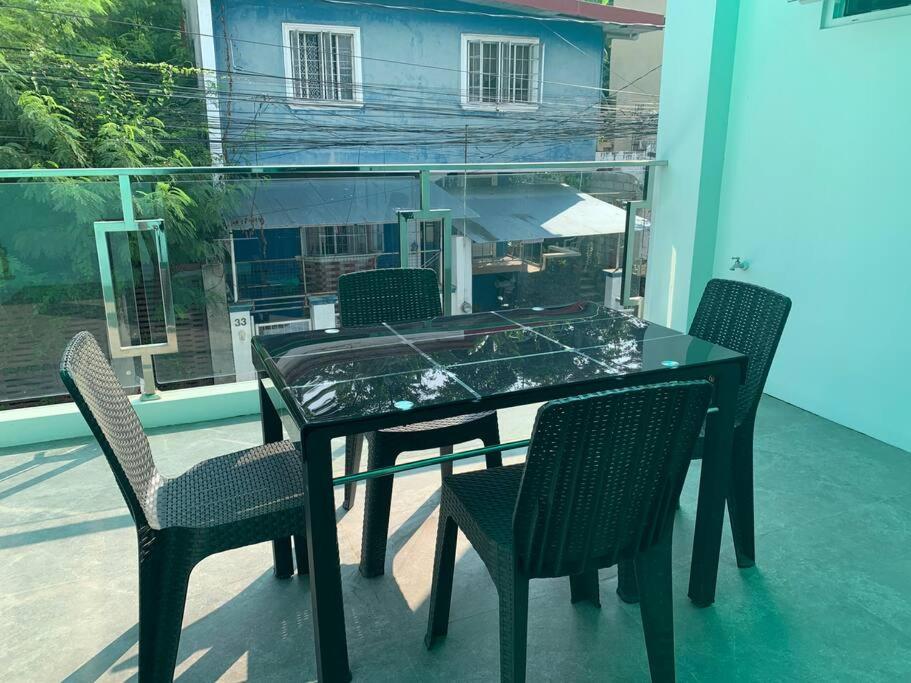 einen Glastisch und Stühle auf dem Balkon in der Unterkunft Mansion house in Antipolo
