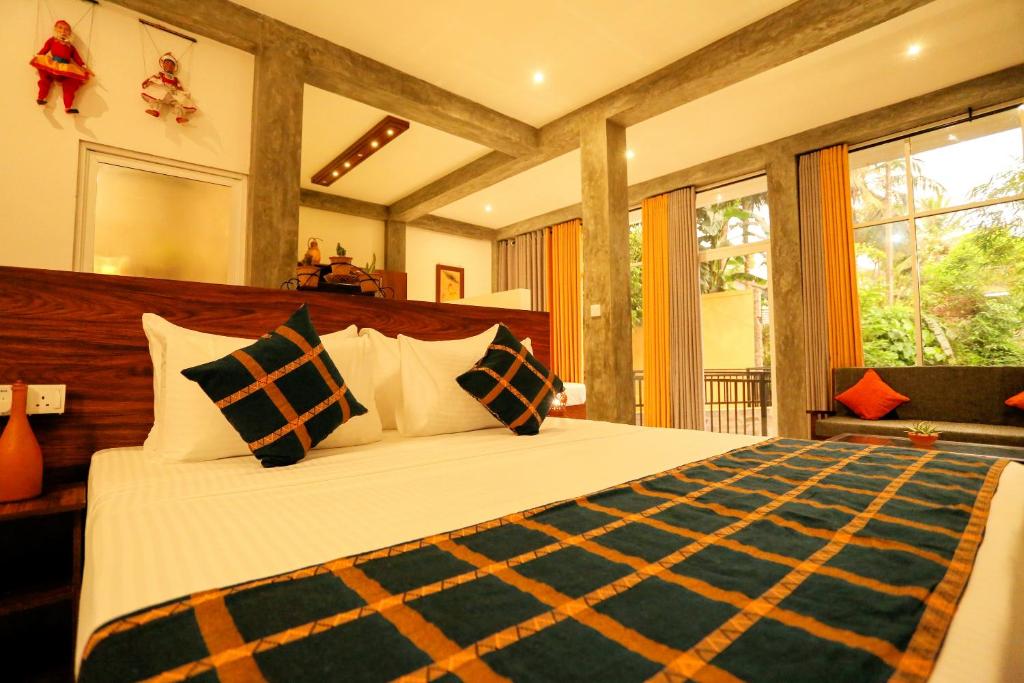 a bedroom with a large bed with pillows at Villa Sanni 18 in Hikkaduwa