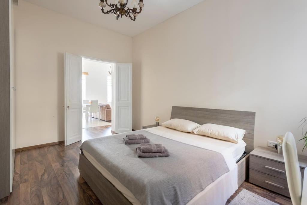 a bedroom with a large bed with two towels on it at Modern stylish flat near Valletta and Sliema! in Msida