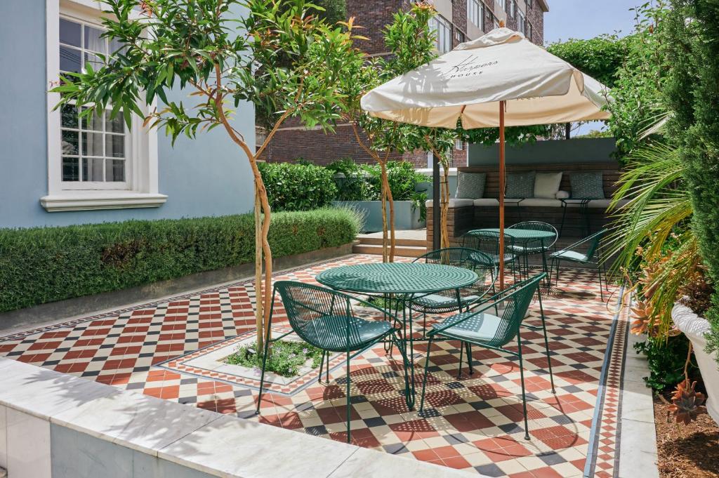 a patio with two tables and an umbrella at Harpers House in Cape Town