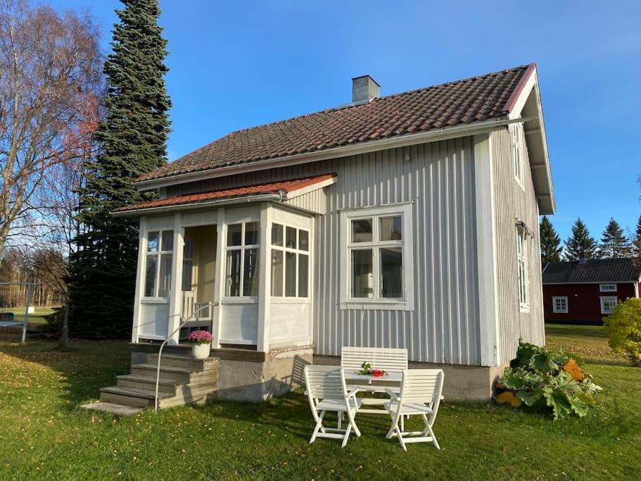 a small house with two chairs and a table in the yard at Charmig stuga på bondgård in Norrfjärden