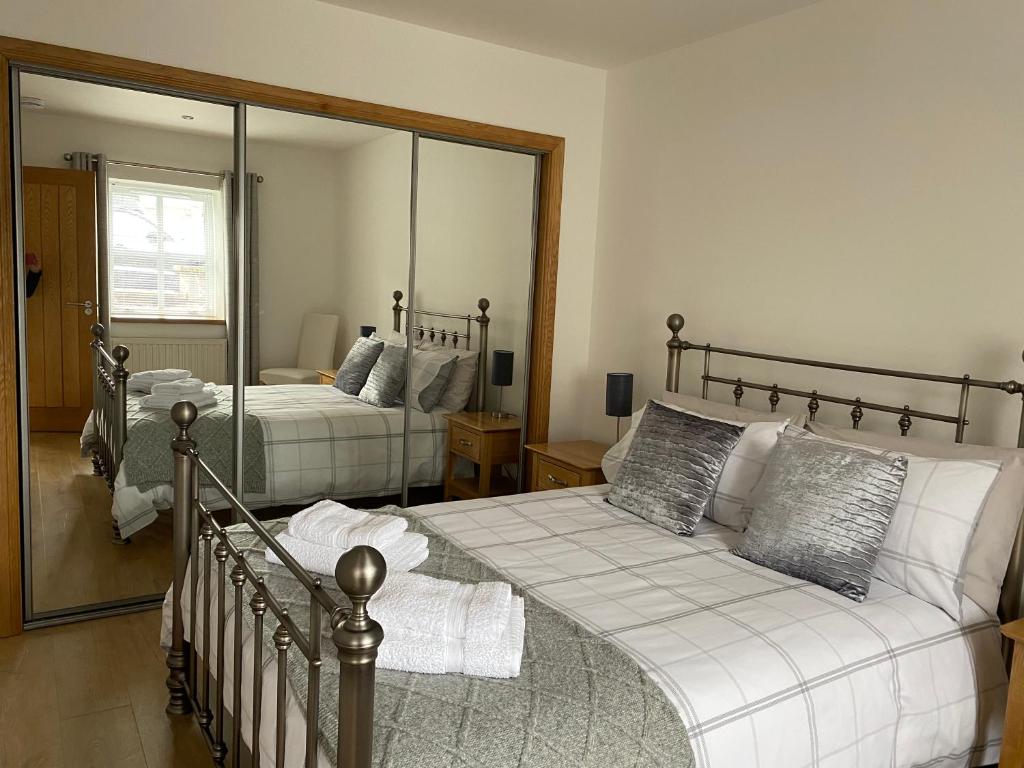 a bedroom with two beds and a large mirror at The Den in Stuartfield