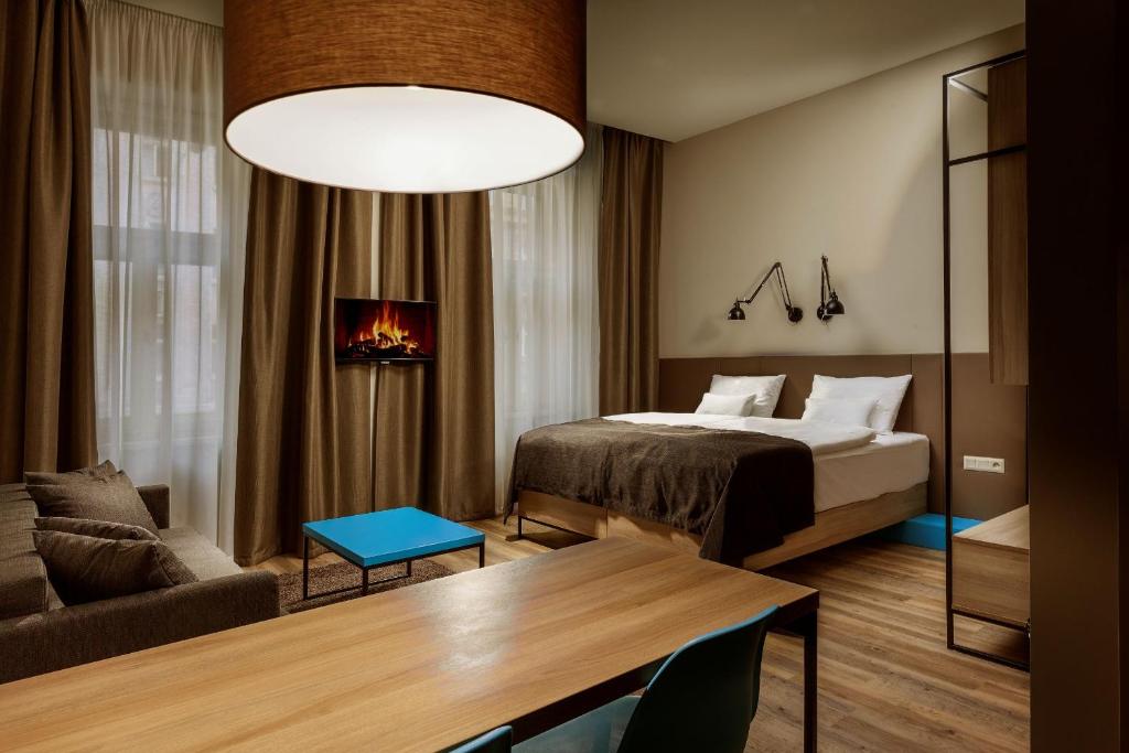 a bedroom with a bed and a living room at Avenue Legerova 19 in Prague