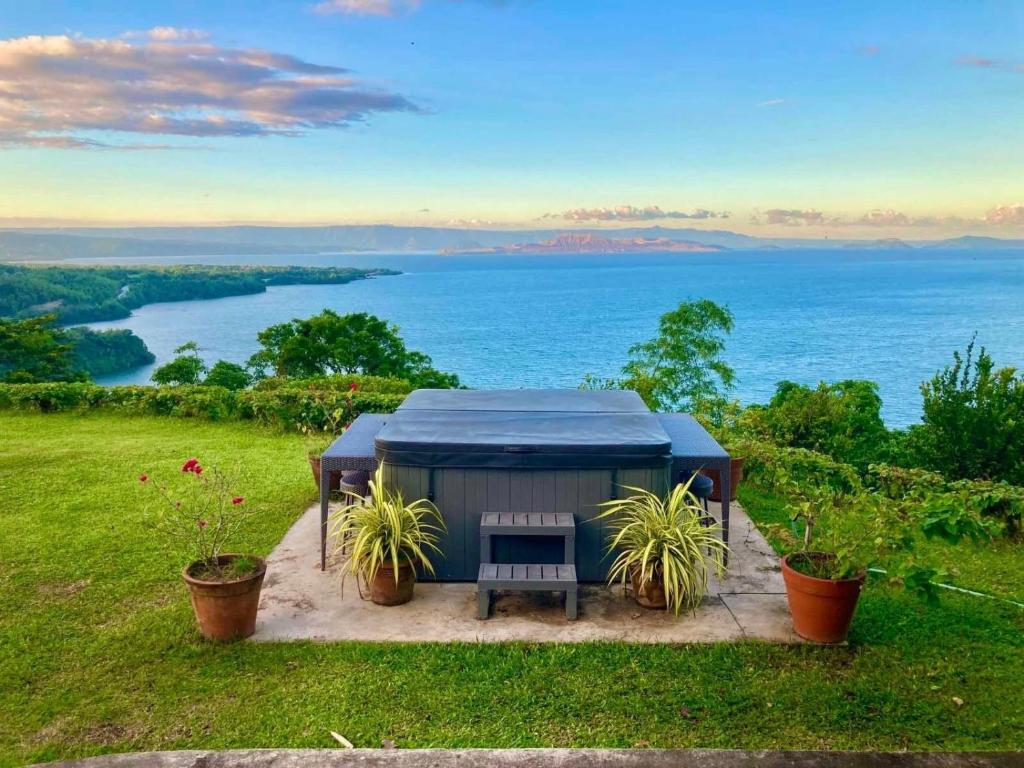 a gazebo with a bench and a view of the water at Ataalaya Farmhouse in Batangas City