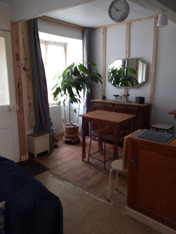 Cette chambre comprend un bureau, une table et une horloge. dans l'établissement Au 17, à Murat