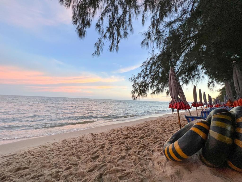 a beach with chairs and umbrellas and the ocean at Sky&Sea Cha-AM Beach in Cha Am