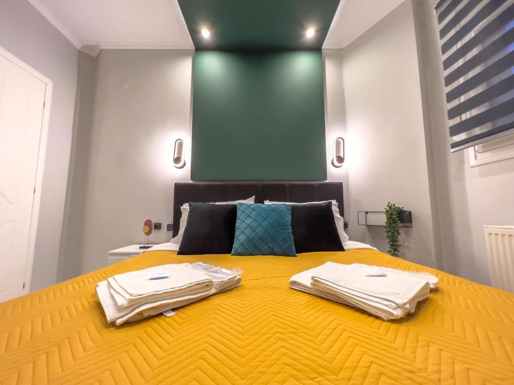 a bedroom with a large yellow bed with towels on it at eliTe deluxe in Kavala