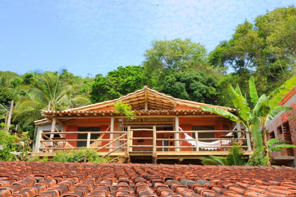 a house with a tiled roof in front of it at Casinha Caiçara in Ilhabela