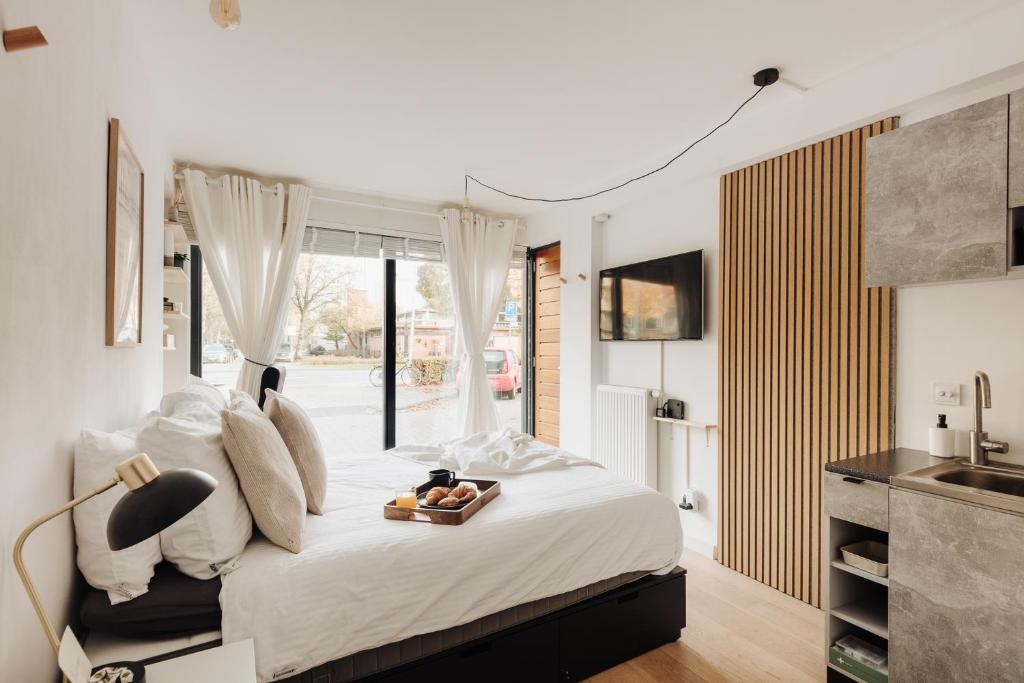 a bedroom with a bed with a tray of fruit on it at Luxurious Private Studio Amsterdam Zuid in Amsterdam