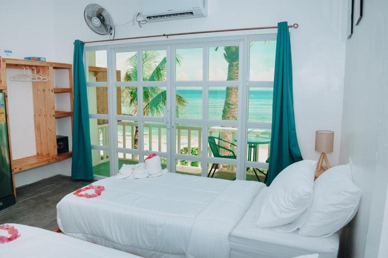 een slaapkamer met een bed en een groot raam bij johandive in Daanbantayan