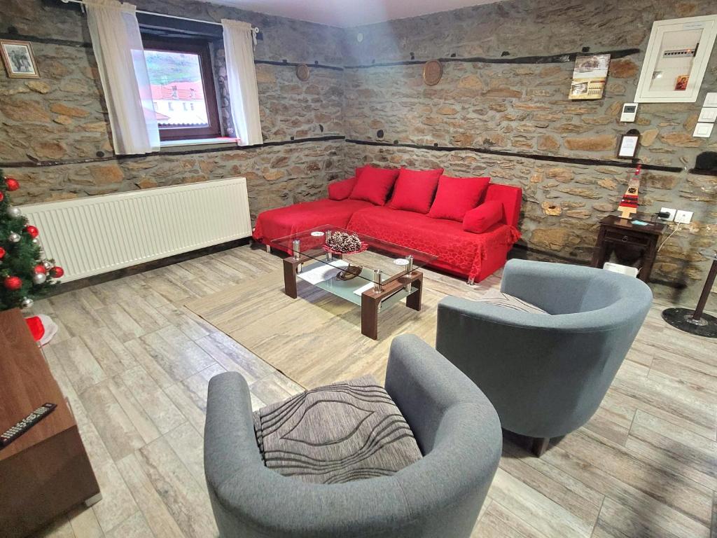 sala de estar con sofá rojo y 2 sillas en Traditional Stone Villa "To Petrino", en Florina