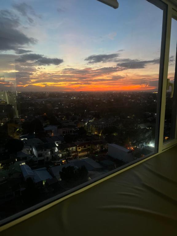 a view of a city from a window at sunset at Fully Furnished 1 bedroom Condo Las Pinas in Manila
