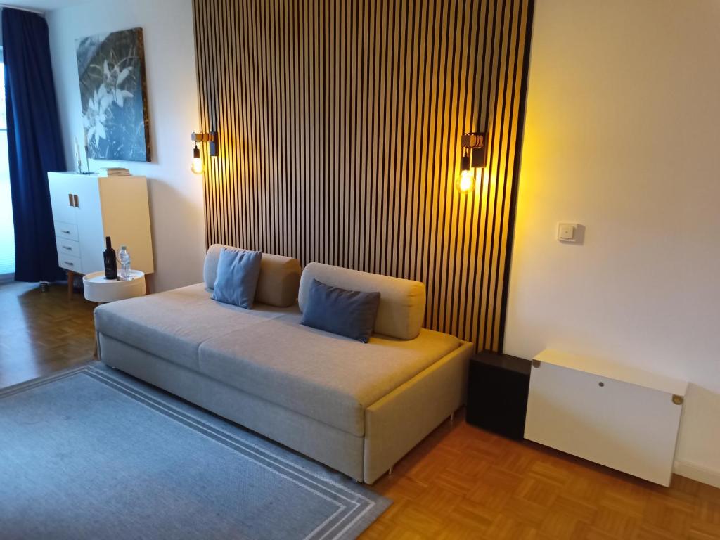 uma sala de estar com um sofá com almofadas azuis em Cosy little apartment em Munique