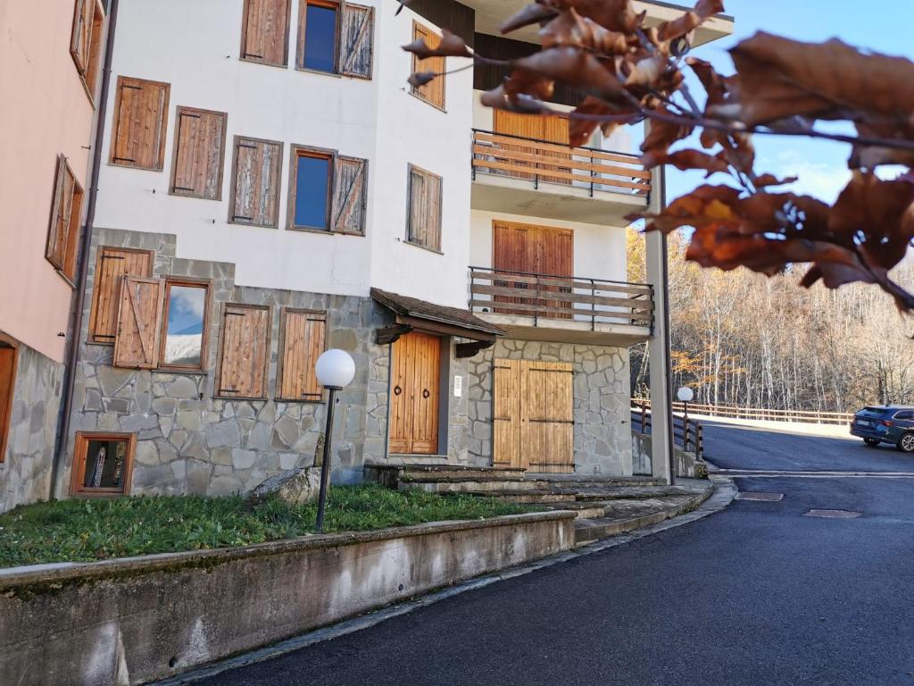 ein Gebäude mit Seitentüren aus Holz in der Unterkunft La Casetta degli Gnomi in Faidello