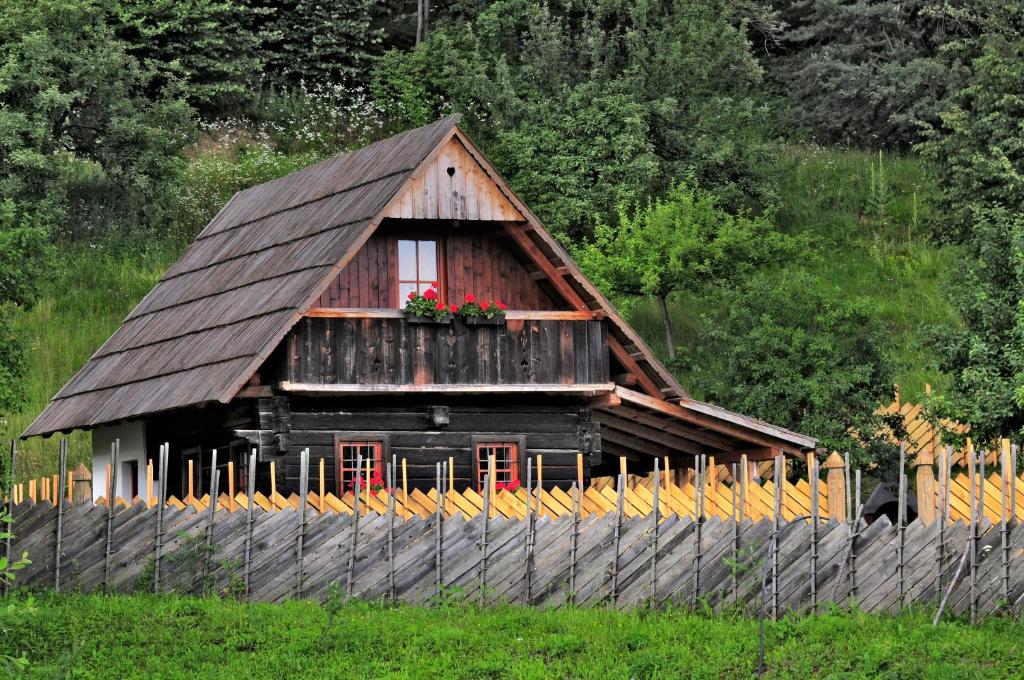 ein Holzhaus mit einem Fenster mit Blumen darauf in der Unterkunft Eco tourist farm Mikl in Prevalje