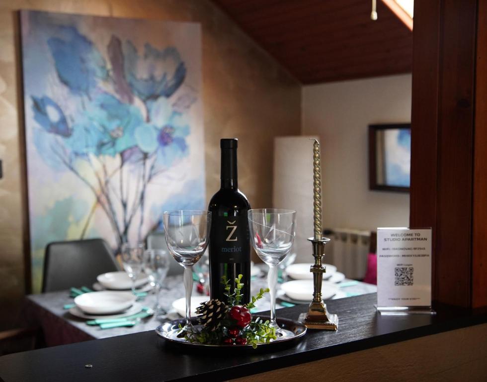 a table with a bottle of wine and wine glasses at Roba's Apartment in Zagreb