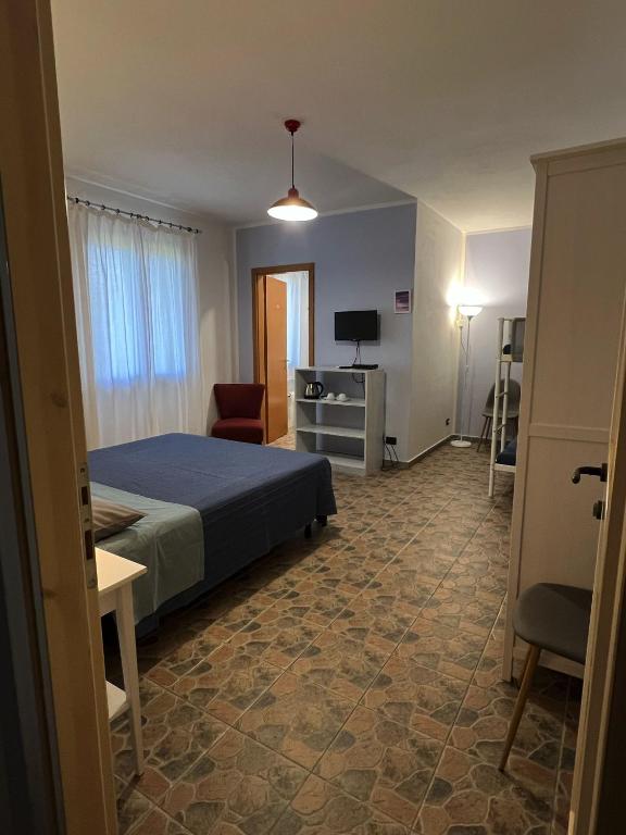 een slaapkamer met een bed, een stoel en een televisie bij Agriturismo Graziano e Barbara in Porto Conte