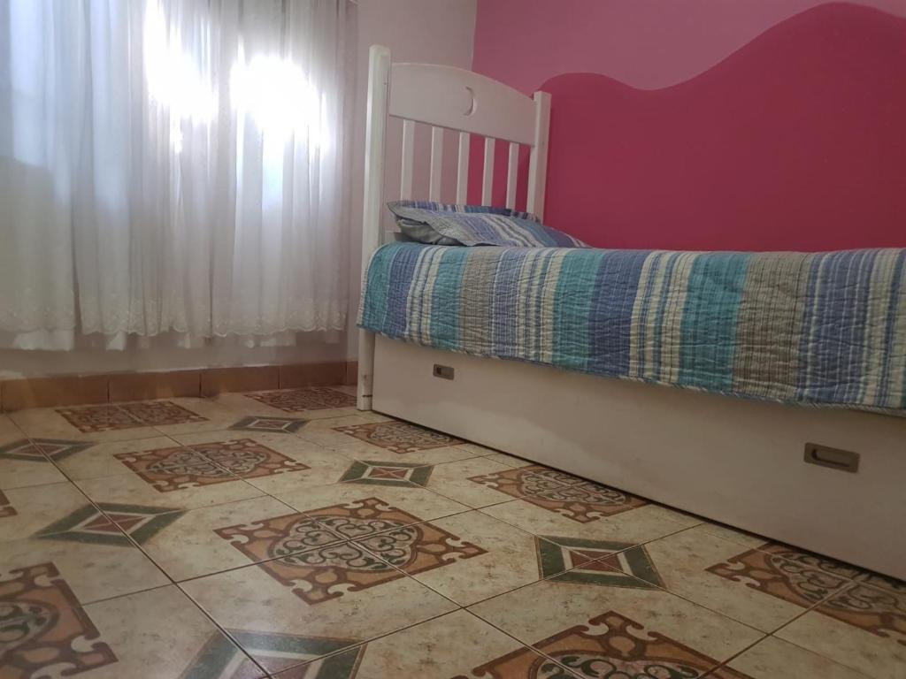 1 dormitorio con 1 cama y suelo de baldosa en Viví Iguazú Casa Familiar en Puerto Iguazú