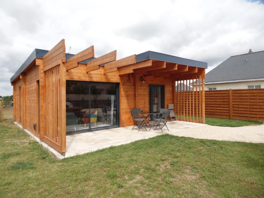Cette petite maison en bois dispose d'une terrasse dans une cour. dans l'établissement Chalet cosy climatisé avec parking et Internet, à Doué-la-Fontaine