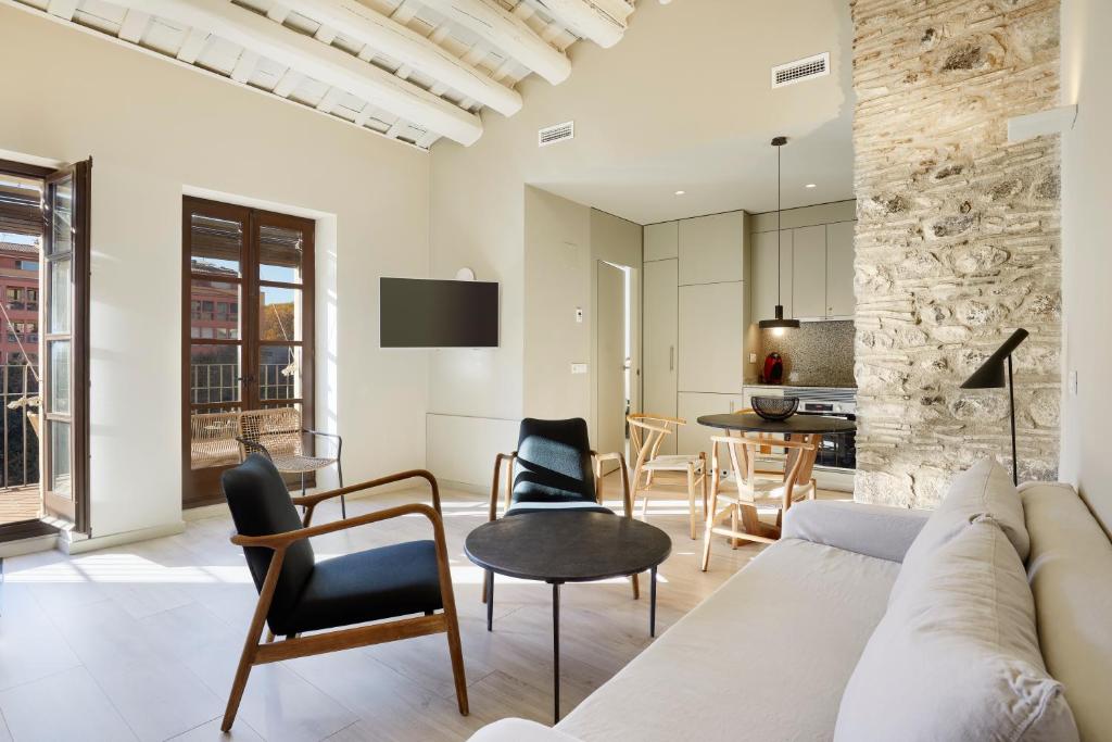 - un salon avec un canapé, des chaises et une table dans l'établissement Canvas Apartments & Lofts Girona, à Gérone