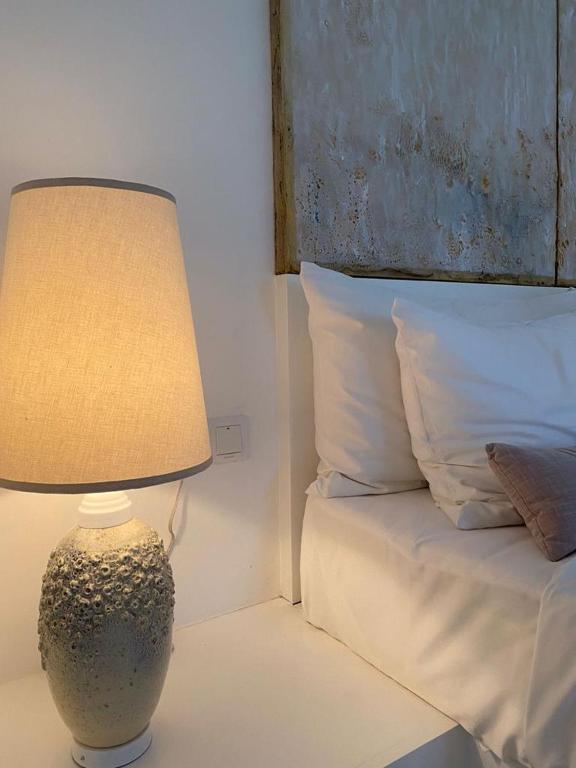 a lamp sitting on a table next to a bed at Saffron Robes Living in Hikkaduwa