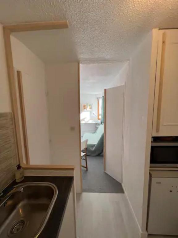 une cuisine avec un évier et une chambre avec un lit dans l'établissement Modern studio in the heart of the station 1650, aux Orres