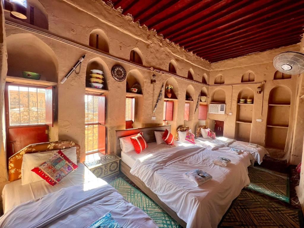 um quarto com três camas e janelas em Al Misfah Hospitality Inn em Misfāh