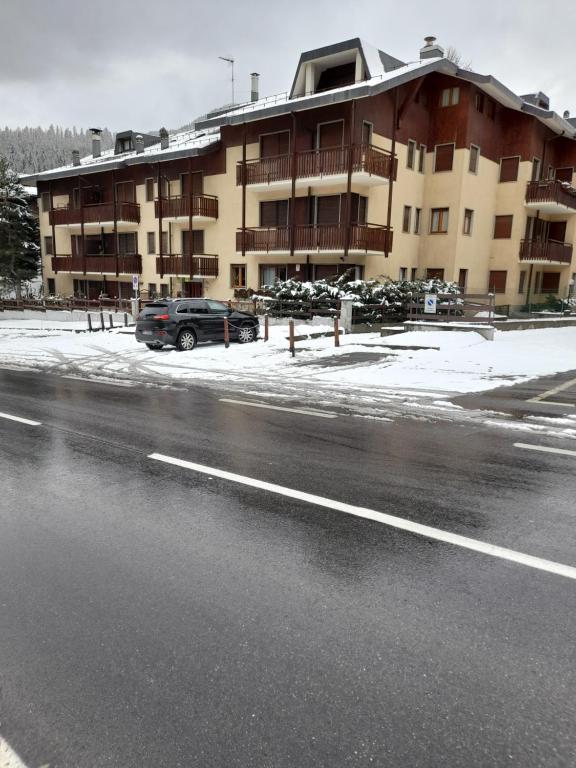 a parking lot next to a large building with snow at Einaudi 9 in Bardonecchia