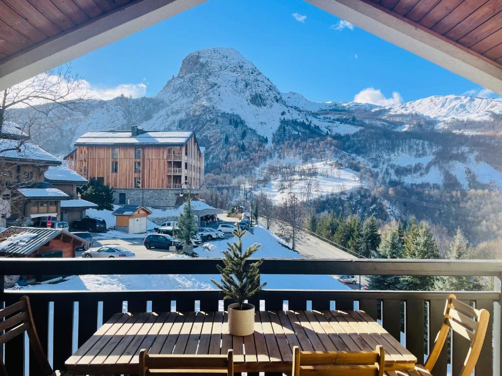 a table on a balcony with a view of a mountain at Front de Neige de St Martin de Belleville - Appartement 60 m2 - 8 personnes - Residence Les Murgers in Saint-Martin-de-Belleville