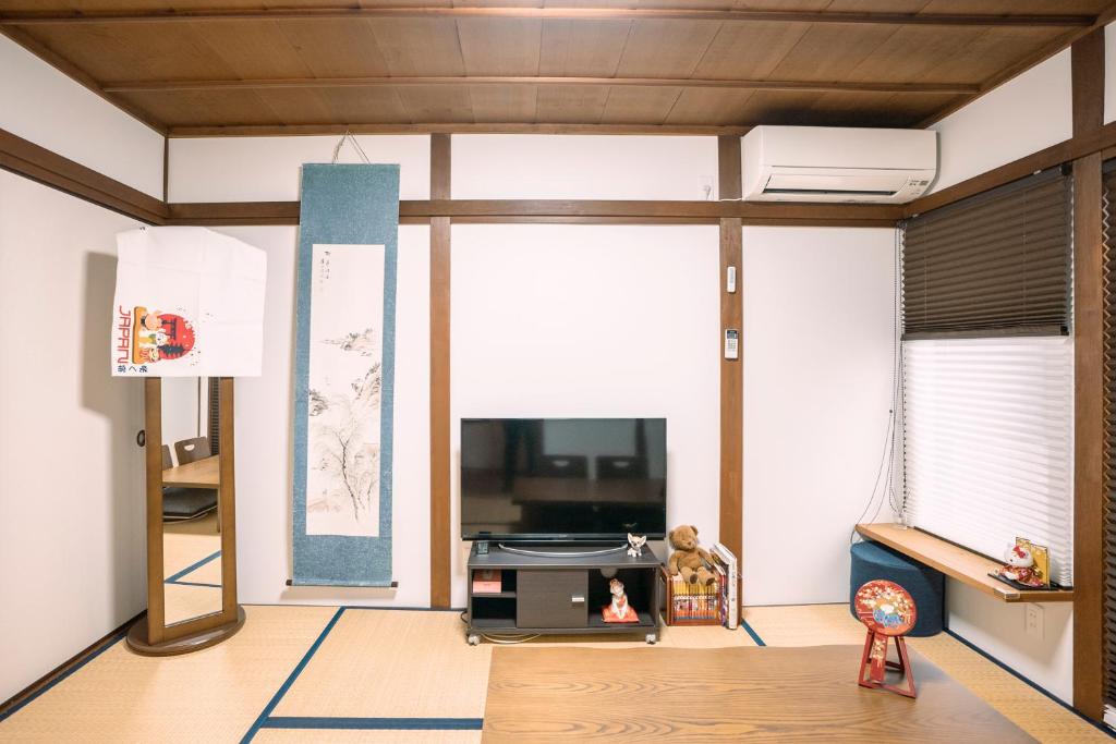 een woonkamer met een tv en een bank bij Tofukuji Saku Inn（东福寺咲く宿） in Kyoto