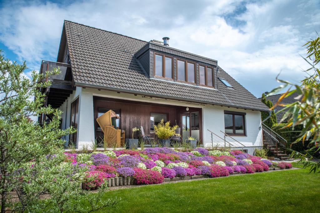 a house with a flower garden in front of it at Ferienwohnung "elbRetreat" in Seevetal-Over an der Elbe - Stilvoll wohnen auf Zeit in Seevetal