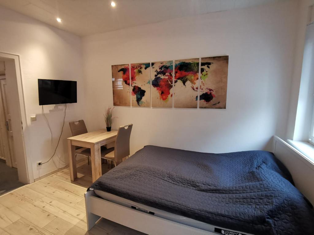 1 dormitorio con 1 cama y 1 mesa con TV en Gemütliches Zimmer mit eigenem Bad und Küche, en Swisttal