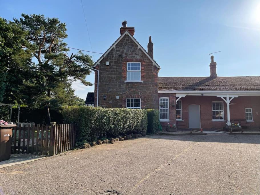 a brick house with a fence in front of it at The Old Station, Station House, Snettisham Norfolk in Snettisham